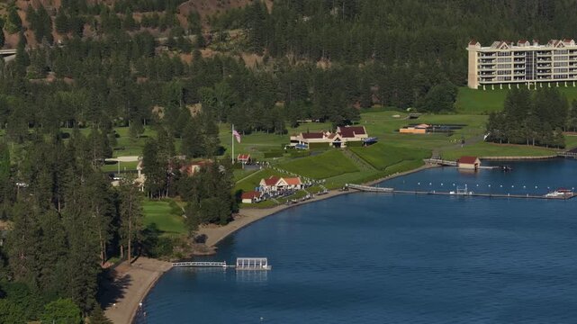 Sunny aerial of resort and marina on lake waterfront in Coeur dAlene Idaho with multistory hotel buildings and golf course