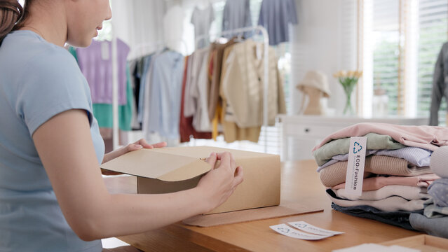 Eco vendor second hand sale go green bio packaging parcel order carton box in net zero waste store asian seller retail. ESG small SME thrift shop owner asia people pack gift shirt reduce social issue.