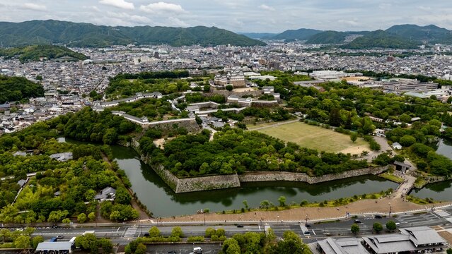 Aerial View of Himeji Castle, Moat and Historic Fortifications Surrounded by Cityscape in Hyogo Japan
