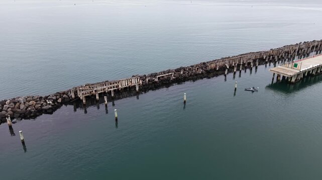 Aerial view of a kayak cruising along a breakwater