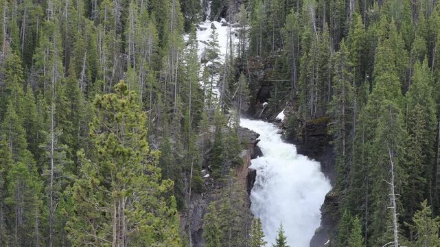 Scenic waterfall on Lake Creek flowing through the mountains beside Beartooth Highway in Wyoming