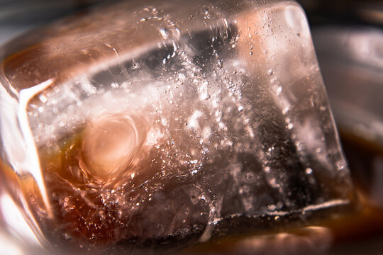 Macro Close Up Shot of a Refreshing Ice Cube Floating in a Glass of Iced Americano Black Coffee