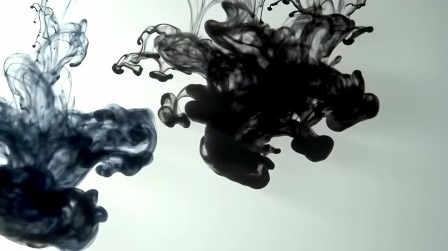 Black ink dissolving in clear water creating abstract swirling cloud shapes and patterns, slow motion