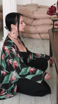 Vertical video. Female meditation. Spiritual zen. Inspired girl cross-legged practicing yoga enjoying calming peaceful aromatherapy candles indoor.