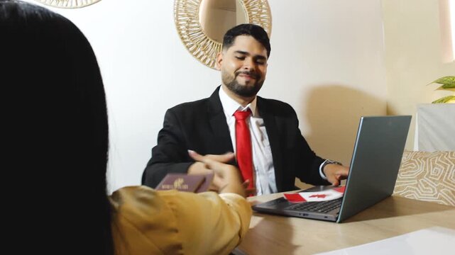 An immigration officer is handing a passport with a visa to a female client who applied to travel to Canada during the holiday season, inside an office in Neiva, Huila, Colombia. Concept of business a