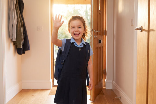 Excited Girl in School Uniform Waving at Front Door