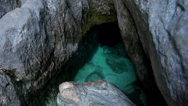 Soca River spring emerges in turquoise karst cave pools in Trenta Valley, static shot