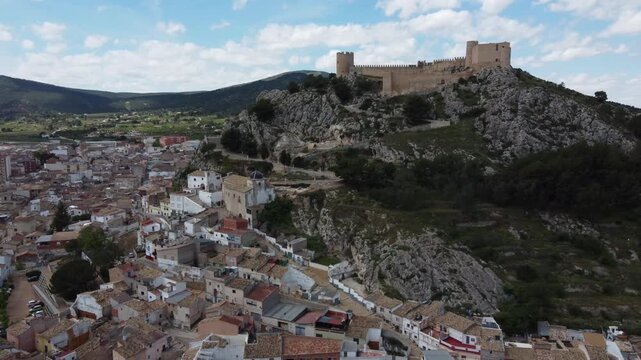 Aerial approach to the castle, Hermitage of the Blood and old town of Castalla, Spain.