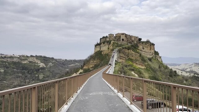 Wide view of the pedestrian bridge connecting the ancient medieval village of Civita di Bagnoregio to the mainland in Italy