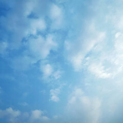 Fototapeta premium A serene blue sky with white clouds and sunshine peeking through the gaps in a natural landscape scene IMG 2561