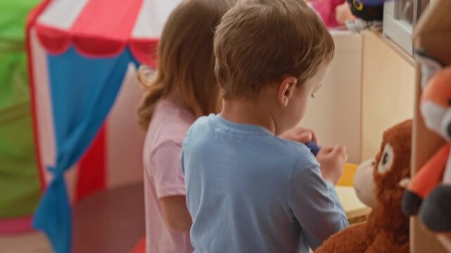 Boy holding toy to stuffed monkey in building playroom while focused on play together; playfulness bonding.