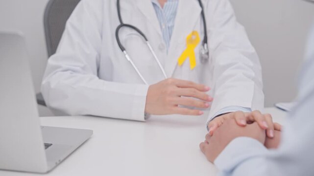 doctor holding patient hand to comfort and support with empathy for Yellow Ribbon concept of yellow September, Suicide prevention day, Childhood, July Sarcoma, bone and bladder cancer Awareness month