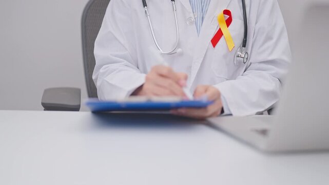 World hepatitis day awareness month, 28 July. doctor using laptop and report notes on notebook. Red and Yellow ribbon for Liver cancer, Jaundice, Cirrhosis, Failure, Enlarged, Hepatic Encephalopathy