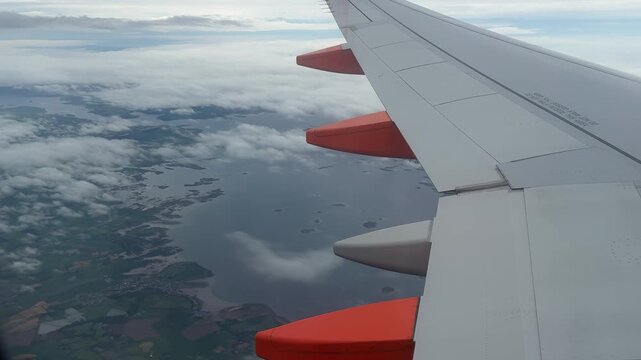 POV from inside a lane looking out to the landscape below passenger Jet going from England to Ireland over the coast UK 4K