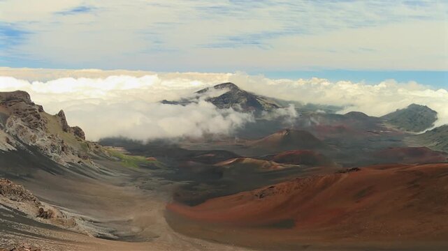 Slow pan right reveal shot of colorful cinder cones and vast volcanic landscape of Sliding Sands Valley from high altitude viewpoint in Haleakala National Park, USA