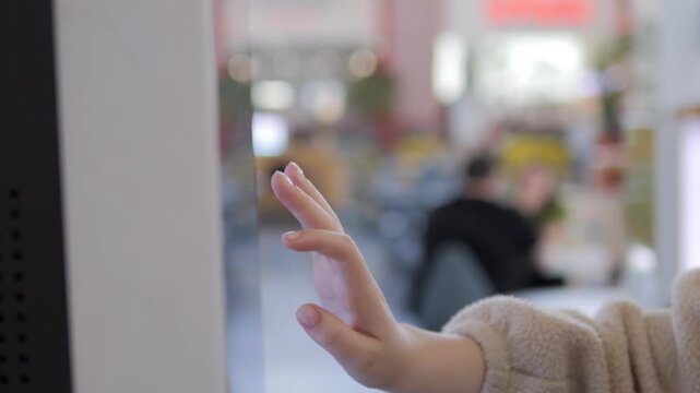 Child's hand gently touches a glass barrier. Soft focus shows blurred indoor setting behind. Small fingers pause, curious and tentative. Could depict safety, curiosity, or transition moments