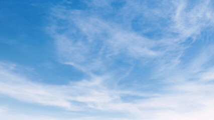 Obraz premium Soft clouds drift through clear blue sky
