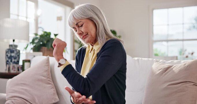 Senior, woman and elbow pain in home with discomfort, nerve compression and osteoarthritis. Retirement, pensioner and joint inflammation in living room with tendon ache, muscle tension and massage