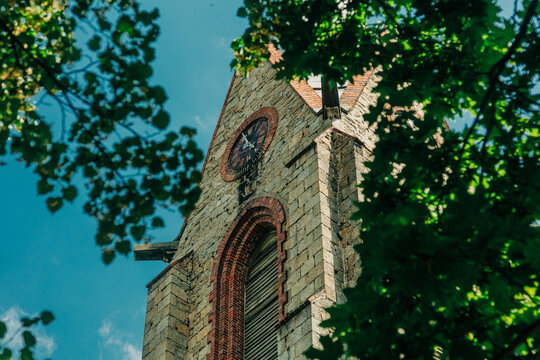 Close-up of 19th century stone tower with bell and clock, Europe, summer.