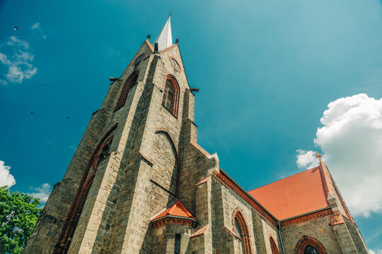 Wide angle of 19th century Catholic Christian stone church, Europe, Poland.