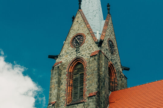 Close-up of 19th century stone tower with bell and clock, Europe, summer.
