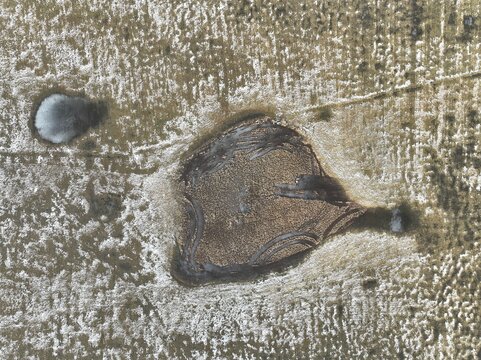 Aerial view of the unique heart-shaped pond in the landscape of Castelluccio, Umbria, Italy.
