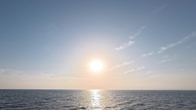 Cinematic sunset time-lapse featuring moving light clouds and gentle ocean waves