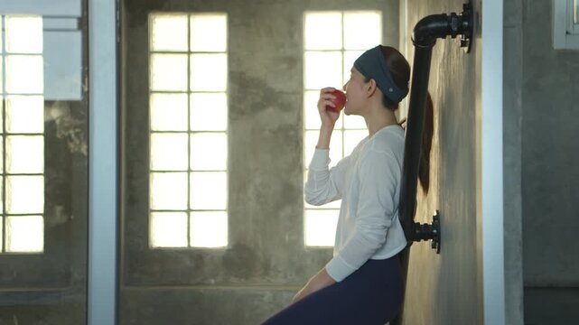 Young woman eating an apple after exercise as part of a healthy fitness lifestyle and nutrition routine
