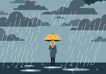 A person stands under a yellow umbrella on a rainy day © Dahlan
