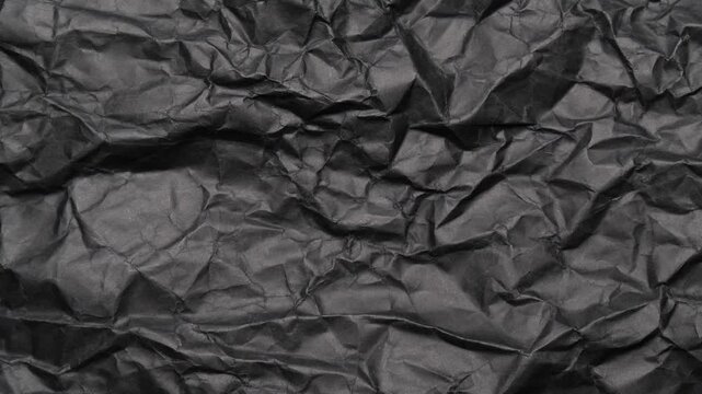 Stop motion of crumpled black paper texture, abstract loop background