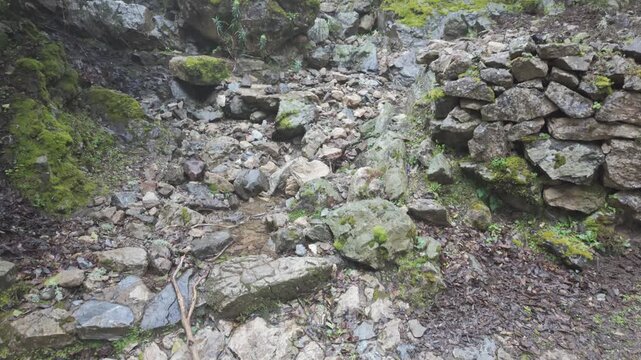 Low Angle Tilt Up Mossy Boulders and Rocky Landscape on Gorropu Canyon Trail in Sardinia Italy