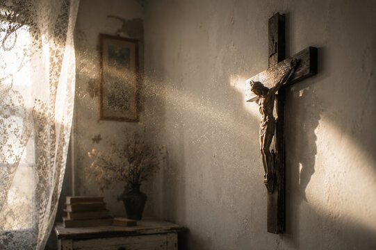 Sunlit crucifix beside a lace curtain in a quiet home