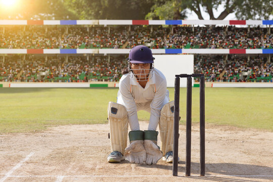 Focused wicketkeeper in position during a cricket game