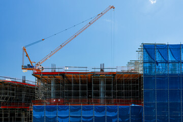 Construction crane building scaffold blue sky architecture urban development steel progress modern site industry structure engineering exterior framework equipment safety © pirom