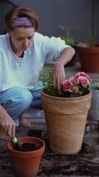 Woman focused on container gardening on a patio