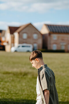 Teenage boy walking through residential green space