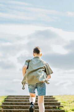 Teenage boy climbing steps outdoors with determination