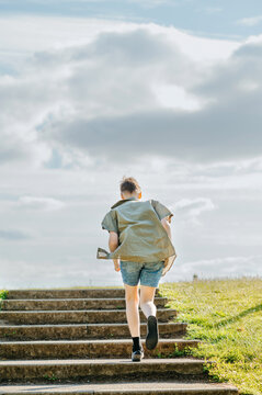 Teenage boy running up outdoor steps in residential park