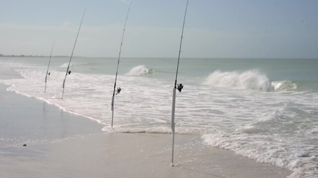 Fishing rods in holders on sandy beach on Anna Maria Island