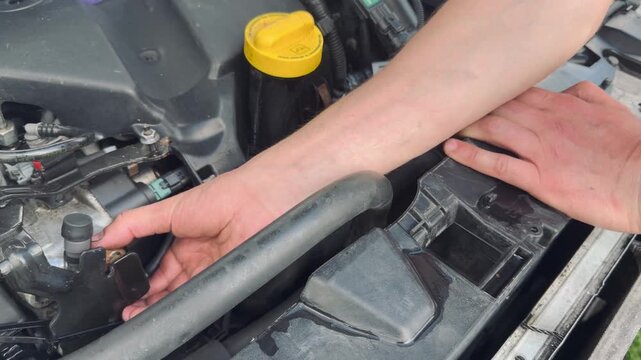 Mechanic inspecting car cooling system and radiator components during vehicle repair