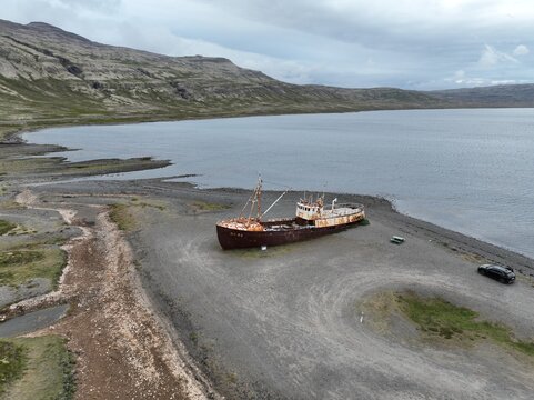 Aerial view of the historic steel ship wreck Gardar BA 64 resting on the gravel shore of the fjord in Saudlauksdalur, Vesturbyggd, Iceland.