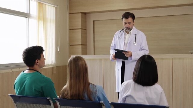 Doctor delivers a medical training session using a tablet while healthcare students attend in a classroom.