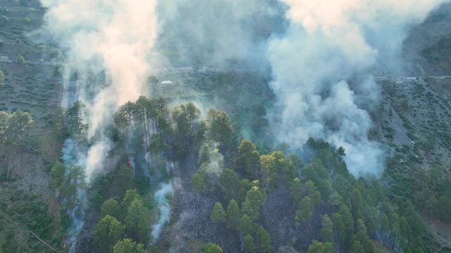Environmental disaster aerial of wildfire spreading in Himalayan hills.