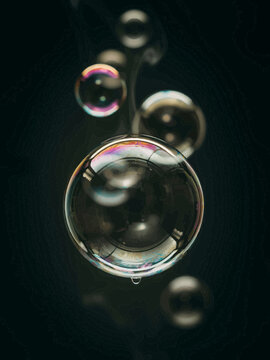 Large Soap Bubbles Floating on Dark Background