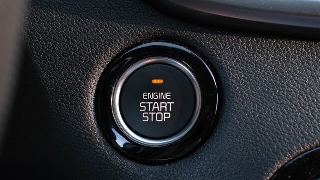 Female hand presses the start button in the car close-up.