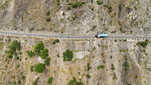 Tracking Drone shot of freight lorries and fuel tanker on narrow mountain pass India.