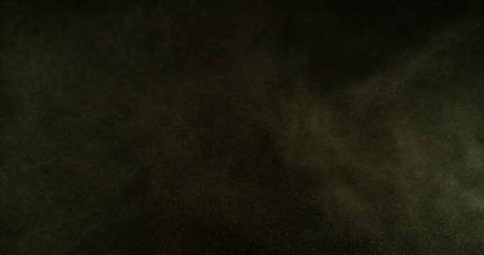 Ultra slow motion dust or sand cloud drifting through the air on a black background. Cinematic particle explosion effect ideal for overlays, compositing, visual effects, motion graphics and VFX projec