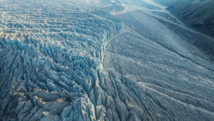 Fototapeta premium Aerial winter landscape of snow-covered Alps and icy mountains meeting ocean horizon under frozen blue sky and clouds