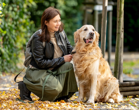 Happy Young Woman With Dog Outside In Autumn