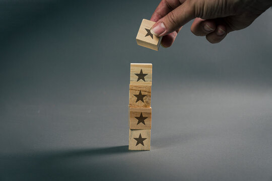 Continuous improvement concept with hand adding star block to quality rating tower